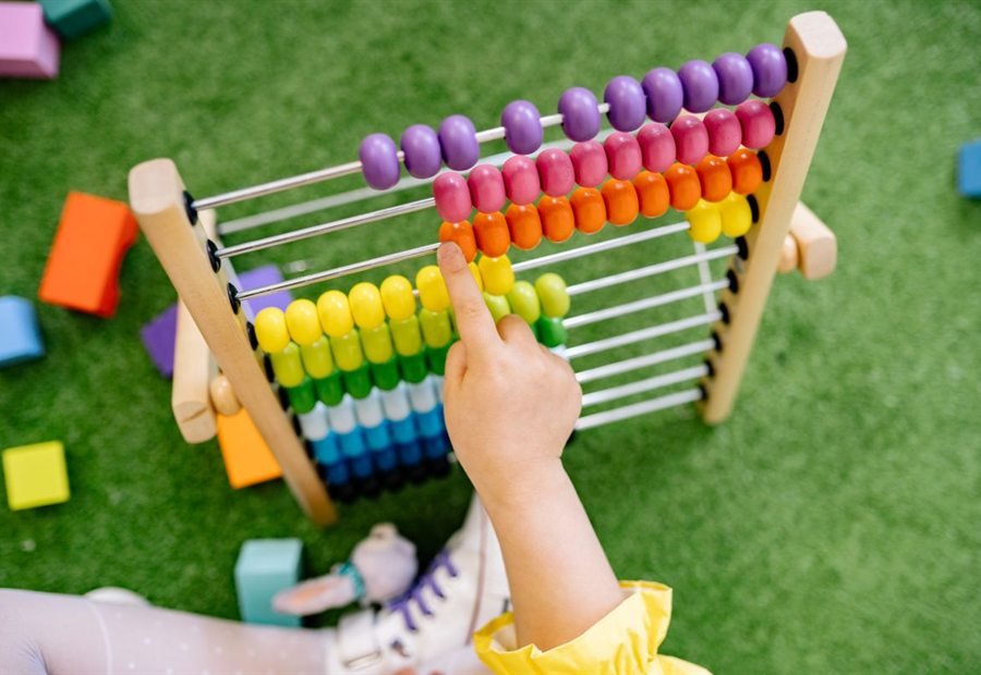 A child counting beads on a colourful abacus