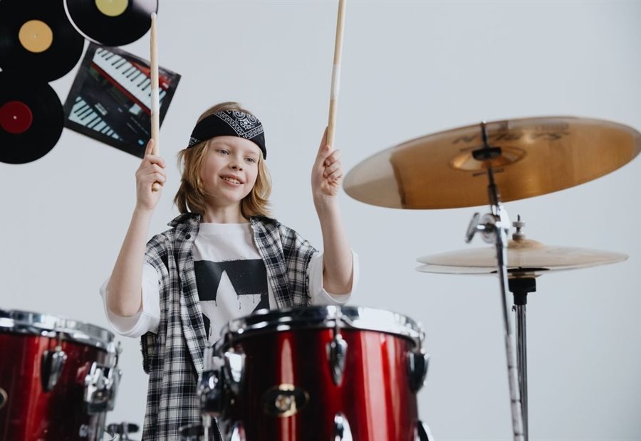 A child playing the drums in the music studio